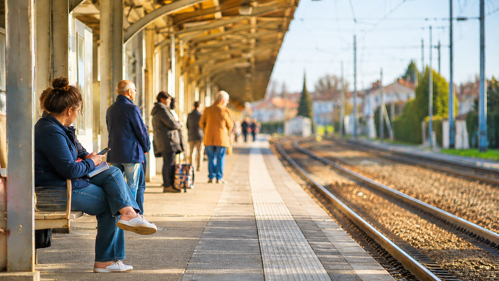 Voyageurs sur le quai d'une gare, attendant leur train.